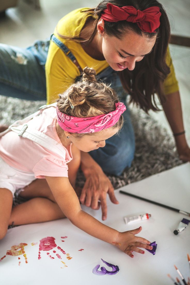 Mãe e filha pintando em casa